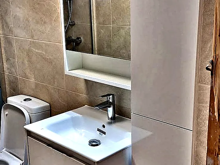 Baño reformado con mueble suspendido y espejo
