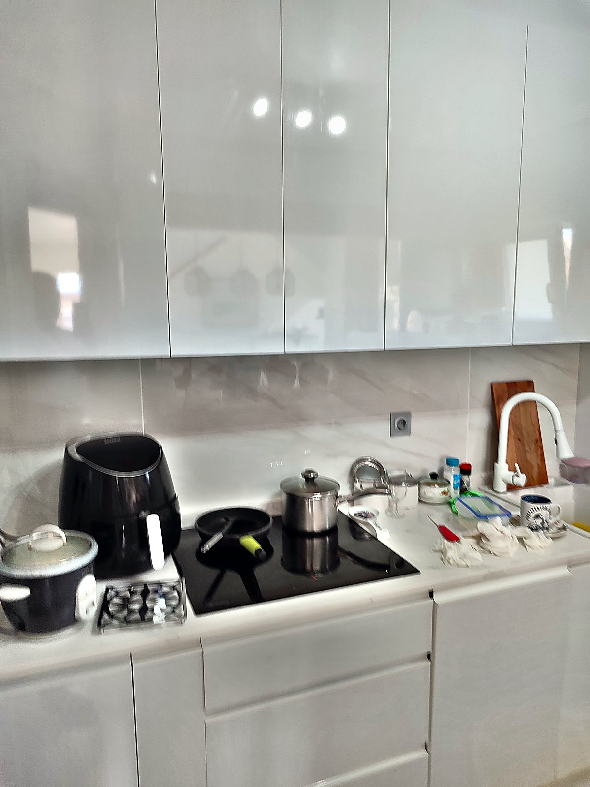 Cocina reformada con muebles blancos y paredes de porcelánico
