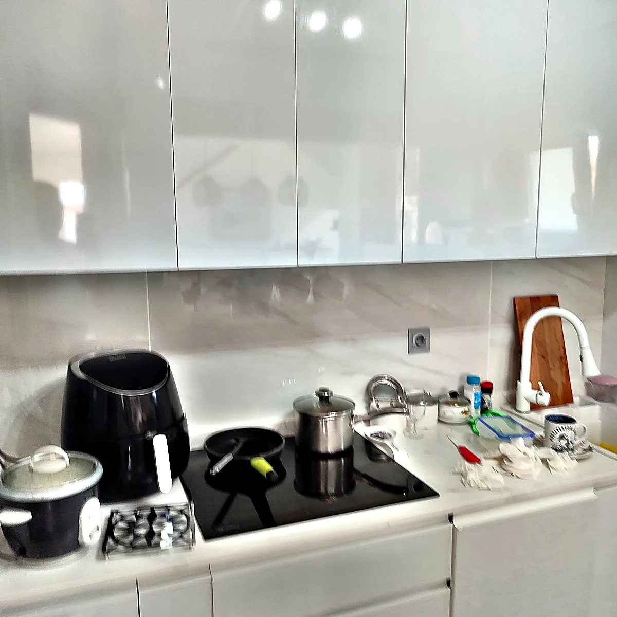 Cocina reformada con muebles blancos y paredes de porcelánico