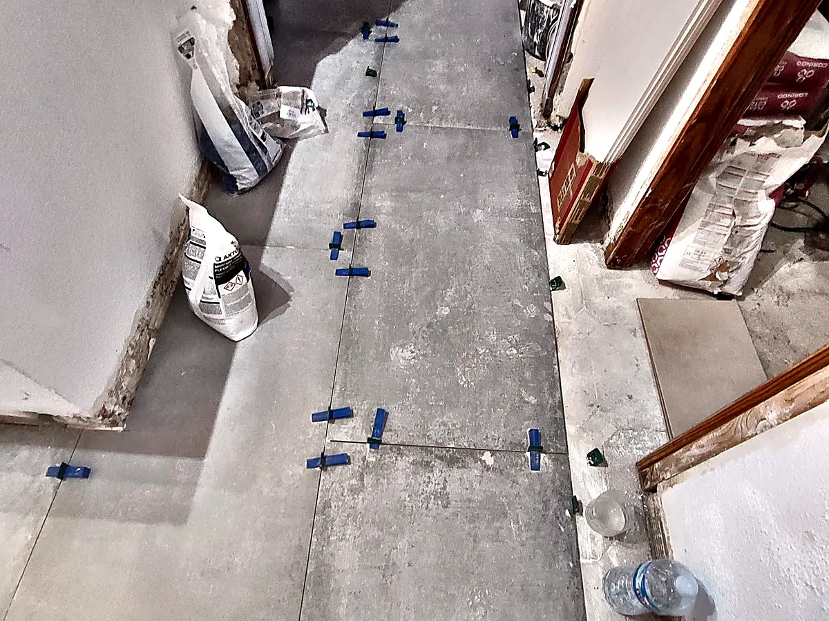 Colocación de suelo porcelánico con niveladores en un pasillo