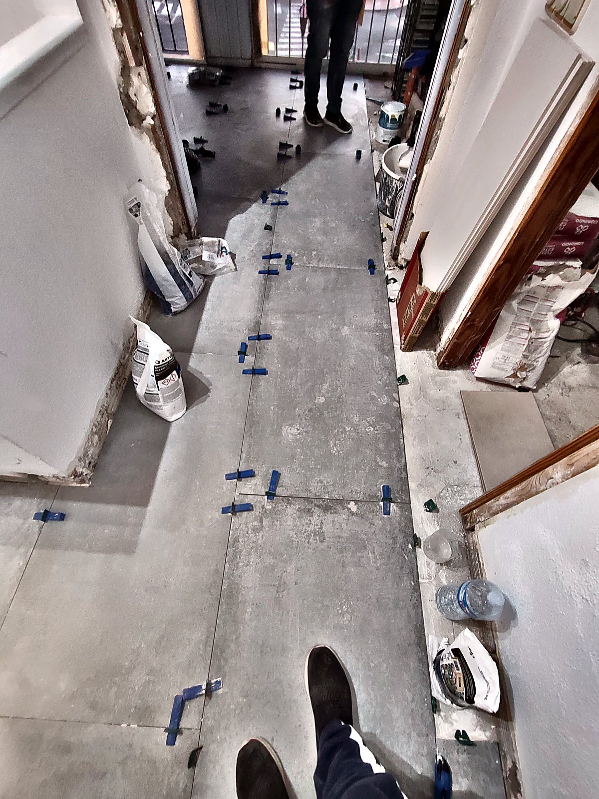 Colocación de suelo porcelánico con niveladores en pasillo