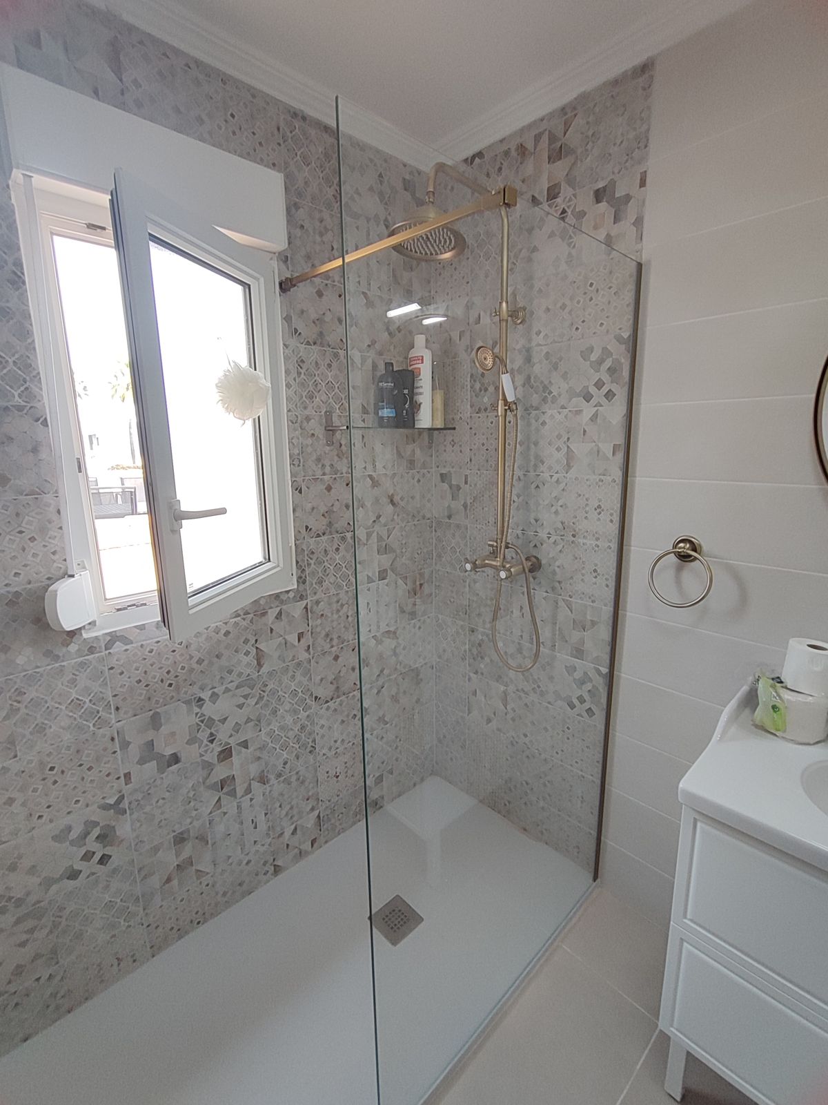 Ducha de obra con grifería dorada y mampara en Murcia