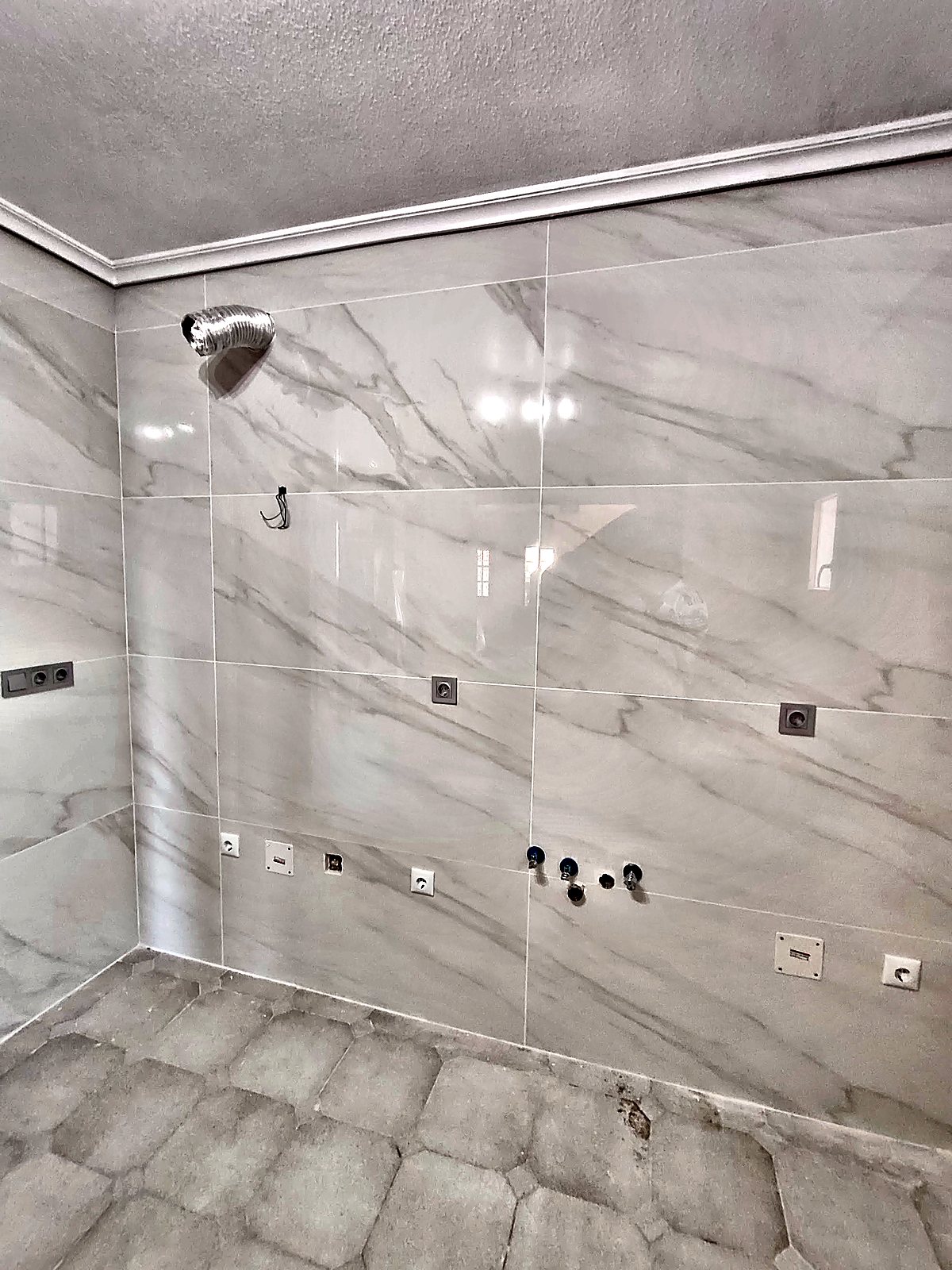 Pared de cocina alicatada con porcelánico blanco efecto mármol
