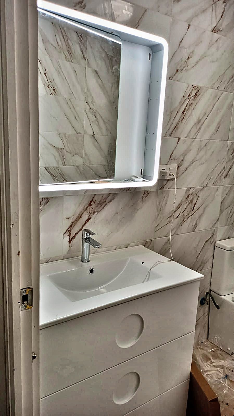 Espejo con luz LED y mueble de lavabo en una reforma de baño en Murcia