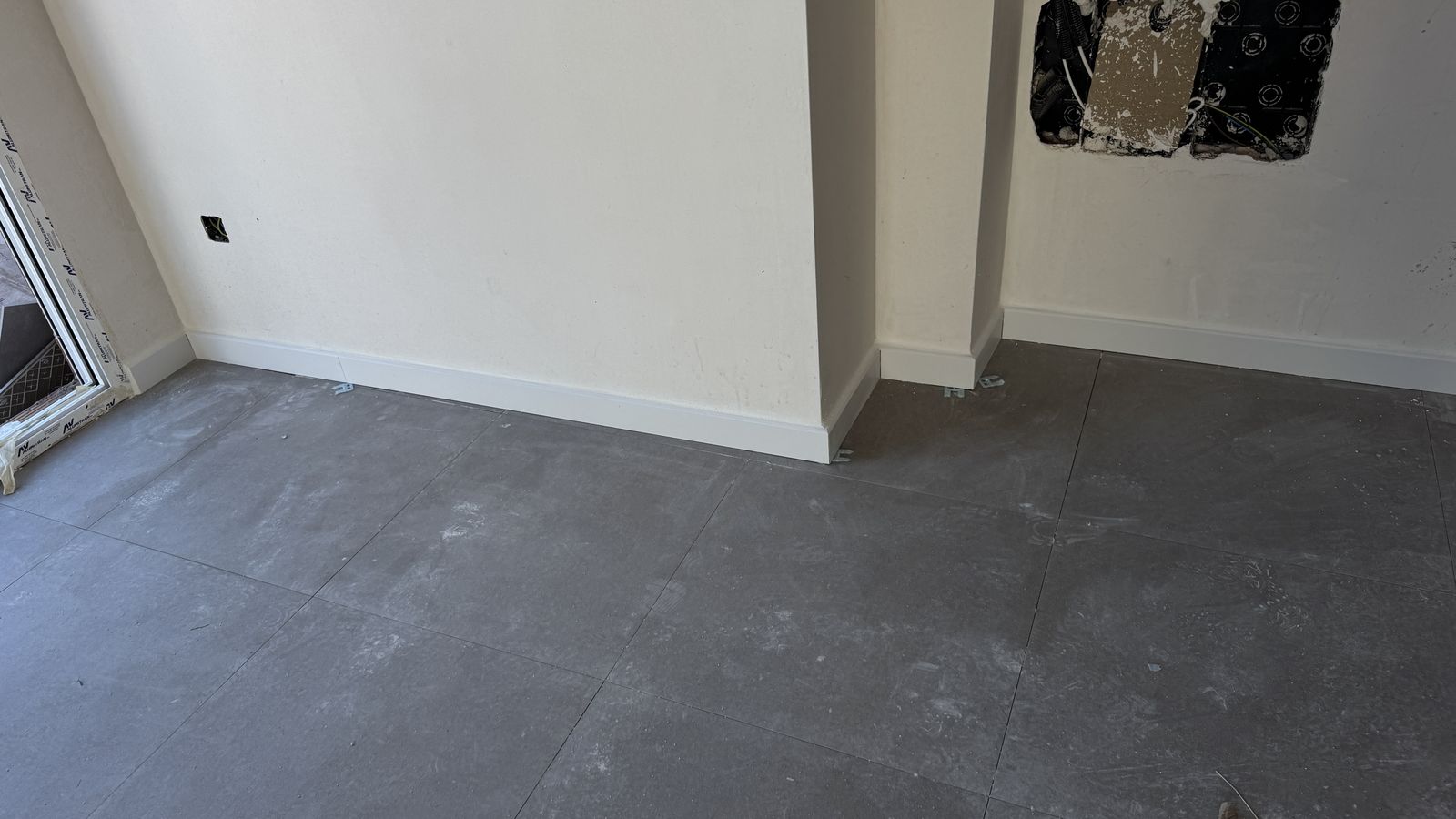 Suelo porcelánico gris recién colocado en una habitación en Murcia