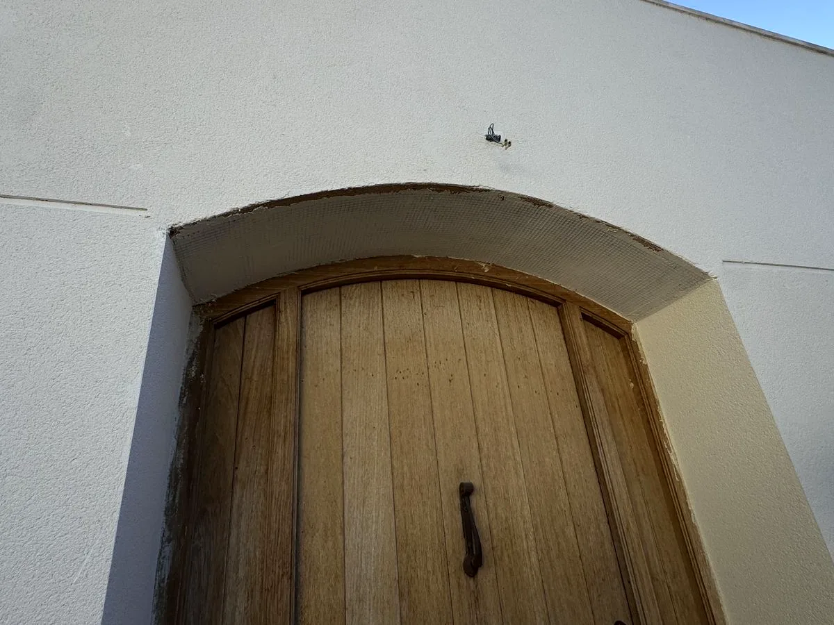 Fachada de monocapa con puerta en arco